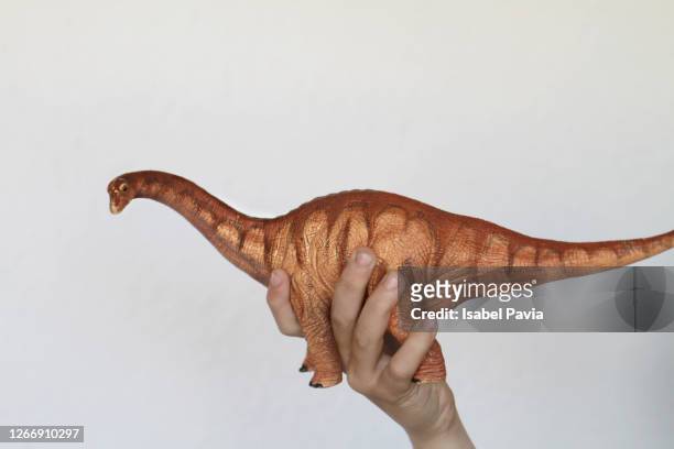 hand holding toy dinosaur - dinosaur toy i stock pictures, royalty-free photos & images