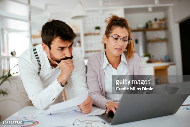 worried young couple with financial bills stock photo - concerned laptop stock pictures, royalty-free photos & images