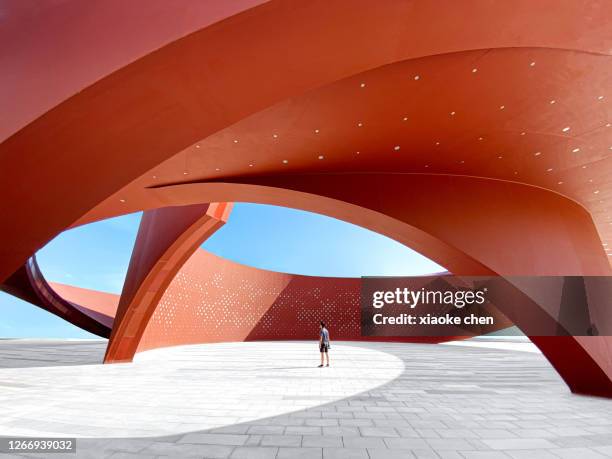 una persona en un espacio arquitectónico abstracto curvo rojo, representación 3d - architecture and art fotografías e imágenes de stock