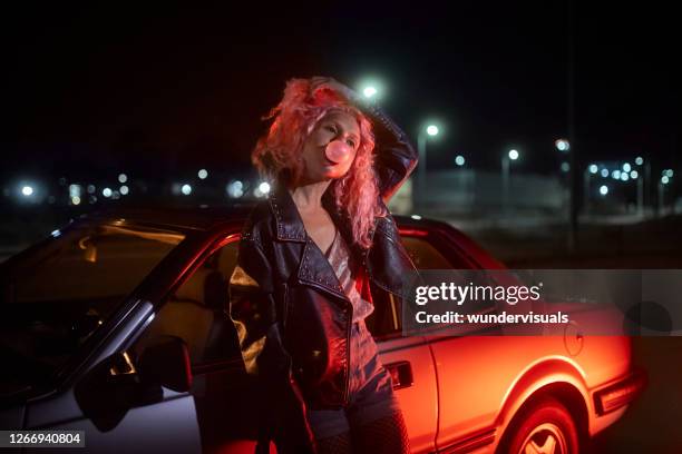 alternative young girl leaning on car with bubble gum at night - 1990 imagens e fotografias de stock