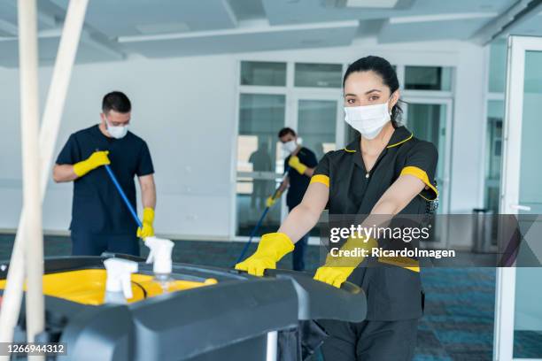 el personal de limpieza está limpiando el edificio para evitar el riesgo de contagio por covid-19 - limpieza profesional fotografías e imágenes de stock