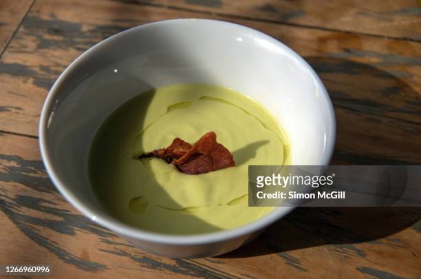 avocado gazpacho soup with a bacon chip and a drizzle of olive oil - avacado oil stock pictures, royalty-free photos & images