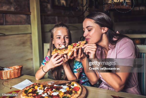 portrait of happy family eating in the restaurant - pizza restaurant stock pictures, royalty-free photos & images