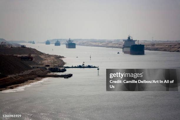 Loaded containers stacked on top of a cargo ship in sigle fine sailing in a canal on Janvier 20, 2017 in Suez Canal, Red sea, Egypt.