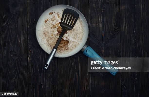 dirty frying pan and skimmer on a wooden table - burnt cooking stock pictures, royalty-free photos & images