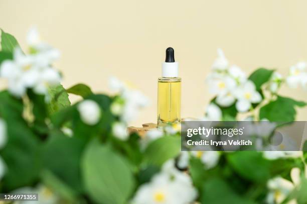 natural cosmetic product, serum or oil for the care of skin and hair with jasmine flowers. - jasmine stock pictures, royalty-free photos & images