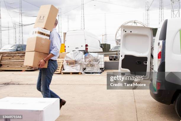 man unloading van with boxes - chargement photos et images de collection