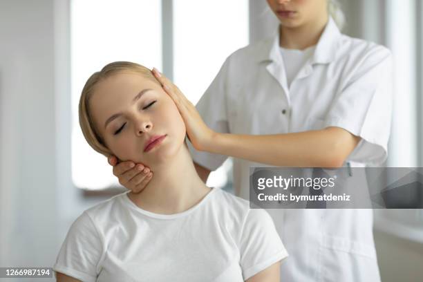 chiropraktiker macht anpassung auf weibliche patienten - head and shoulders stock-fotos und bilder