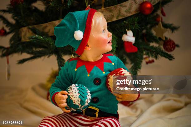 baby disguised as an elf - naughty christmas ornaments stock pictures, royalty-free photos & images