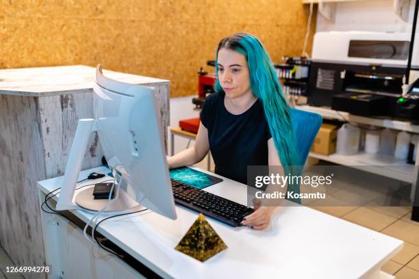 modern young woman receiving online orders on her computer before she start to print on a silk machine - textile printing stock pictures, royalty-free photos & images