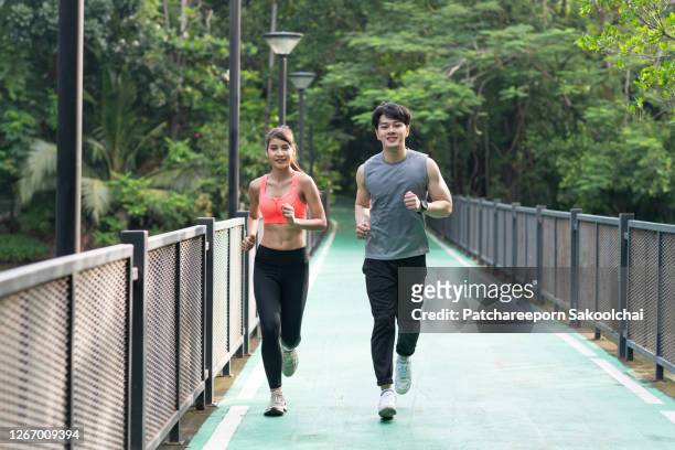 friends jogging in public park - asian six pack photos et images de collection