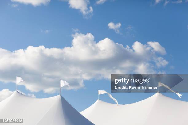 flags on-top of large event tent with clouds and blue sky - entertainment tent stockfoto's en -beelden