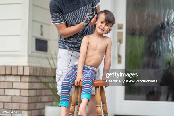 ethnic father gives his son a haircut on the front porch - bad hairdresser stock pictures, royalty-free photos & images