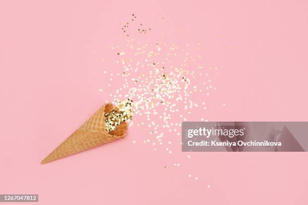ice cream cone with colorful party streamers on pink background. flat lay - trying new food stock pictures, royalty-free photos & images