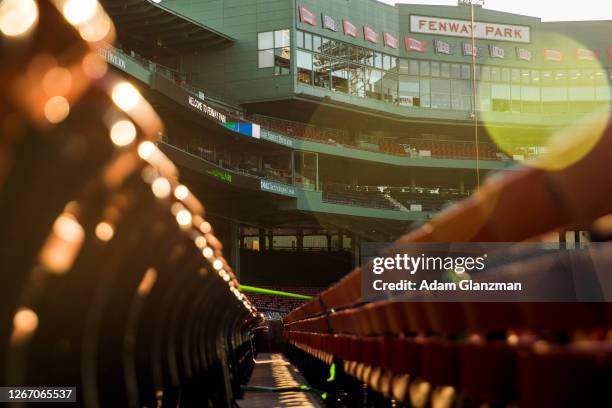 The sun sets over the Fenway Park facade before a game between the Boston Red Sox and the Philadelphia Phillies at Fenway Park on August 18, 2020 in...