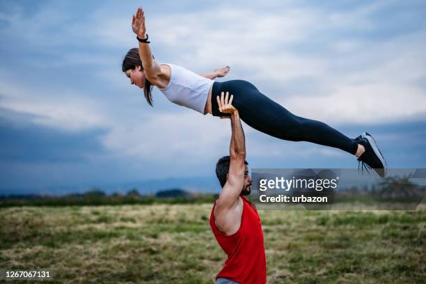 paar macht acroyoga - akrobatische aktivität stock-fotos und bilder