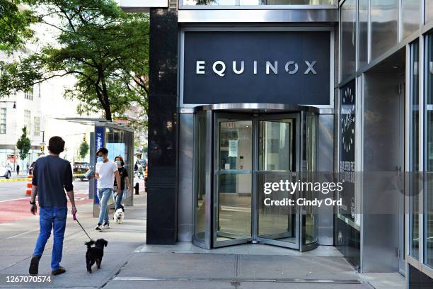 People walk by a closed Equinox gym as the city continues Phase 4 of re-opening following restrictions imposed to slow the spread of coronavirus on...