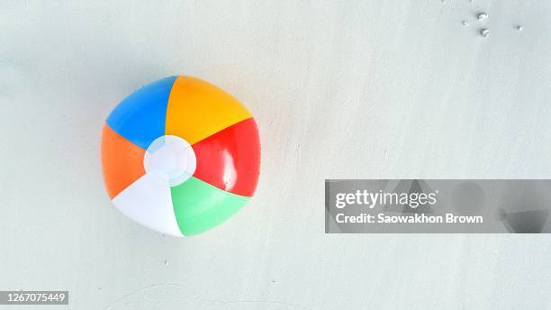 beach ball on white sand background - beach ball stock pictures, royalty-free photos & images