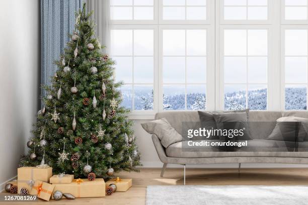 weihnachtsbaum, geschenke und sofa mit blick auf schneebedeckt - christmas tree home stock-fotos und bilder
