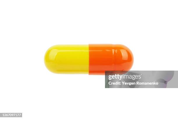 yellow and orange pill isolated on white background - single object stock pictures, royalty-free photos & images