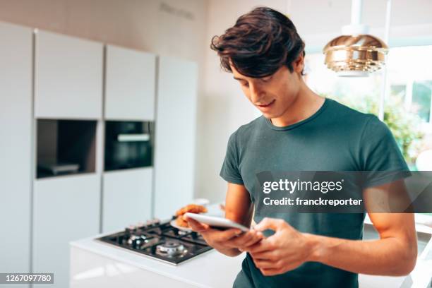 man using the tablet at home in a domotic house - kitchen straighten stock pictures, royalty-free photos & images