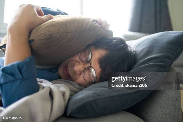 asian business man feeling sick and headache symptoms and sleep on the sofa - infectious mononucleosis stock pictures, royalty-free photos & images