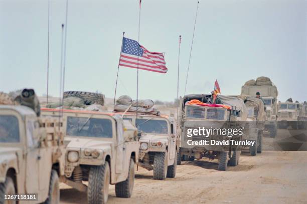 Convoy of US Military vehicles, one flies the stars-and-stripes from the roof, during the Iraqi retreat from Kuwait, 1991. Iraqi troops began...