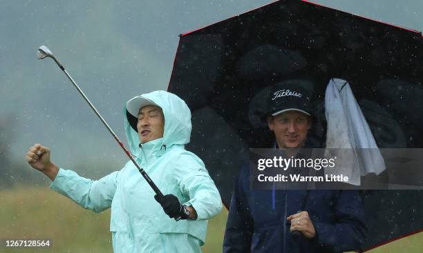 Haotong Li of China celebrates as he chips in on the practice green ahead of the Wales Open at the Celtic Manor Resort on August 19, 2020 in Newport,...