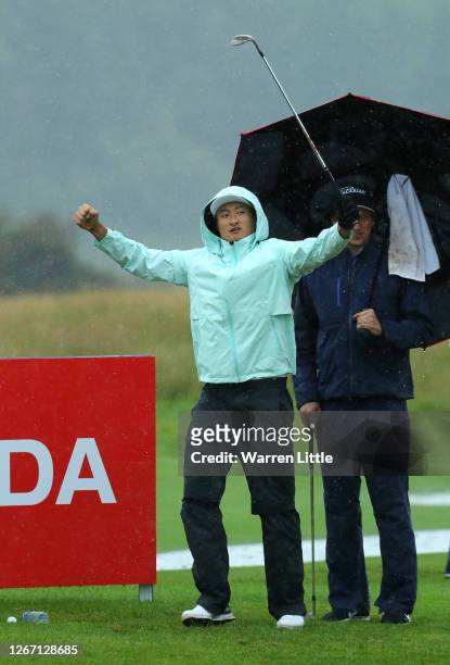 Haotong Li of China celebrates as he chips in on the practice green ahead of the Wales Open at the Celtic Manor Resort on August 19, 2020 in Newport,...