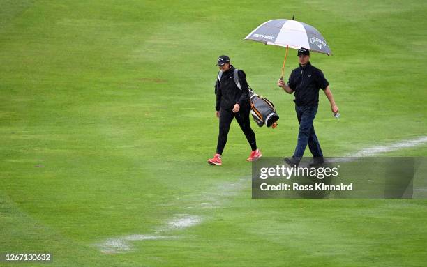 Oliver Fisher of England and his sister Georgina Fisher who is caddying for him this week on the 18th hole during a practice round prior to the Wales...