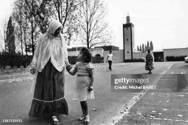 Femme voilée avec sa fille devant la mosquée de Mantes-la-Jolie, dans les Yvelines, en août 1982, France.