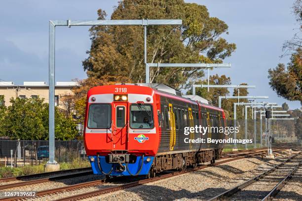 adelaide metro diesel commuter train passing under new electrification works - adelaide train stock pictures, royalty-free photos & images