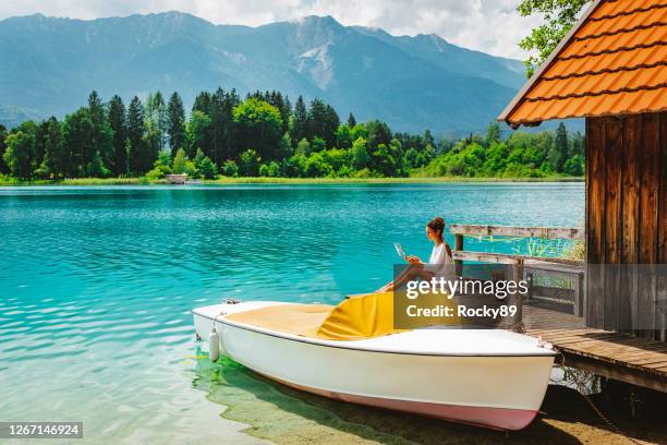 remote working and enjoying bleisure time bij lake faak in oostenrijk - verboten stockfoto's en -beelden