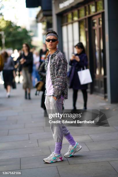 Guest wears a bandanna, sunglasses, a tweed jacket, a pale purple t-shirt, gray sportswear pants, mauve socks, Reebok sneakers shoes, during London...