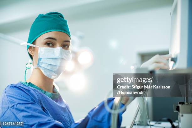 female doctor preparing an anesthesia machine in an operating room - surgery preparation stock pictures, royalty-free photos & images