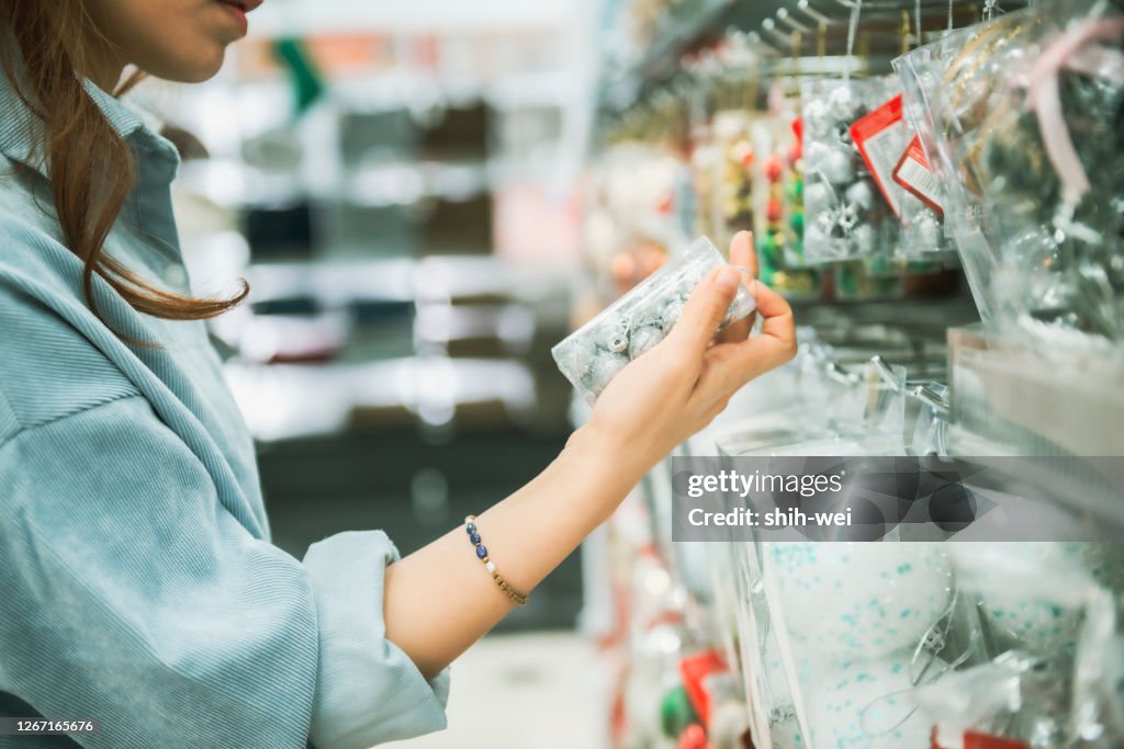 Young Asian woman with cart grocery shopping