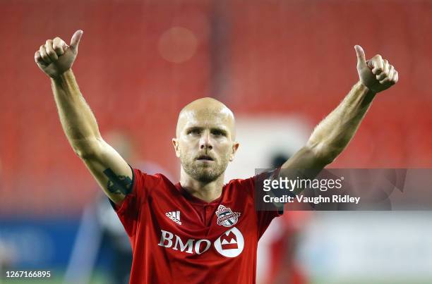 Michael Bradley of Toronto FC applauds fans who managed to gather on a building outside BMO Field following an MLS game against Vancouver Whitecaps...