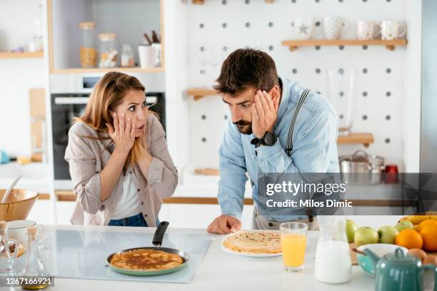 couple kitchen affection stock photo - burnt pot stock pictures, royalty-free photos & images