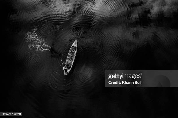 the abstract of lonely fisher men and lonely flooded tree on the lake with black and white version and aerial view - best picture stock-fotos und bilder