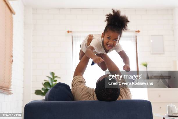 father playing with daughter carrying his daughter over the air to fly - pretending to be a plane stock pictures, royalty-free photos & images