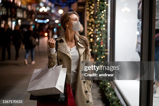 Frau Weihnachtseinkauf mit einer Gesichtsmaske Frau Weihnachtseinkauf mit einer Gesichtsmaske