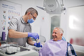 Dentist explaning denture work to happy senior patient