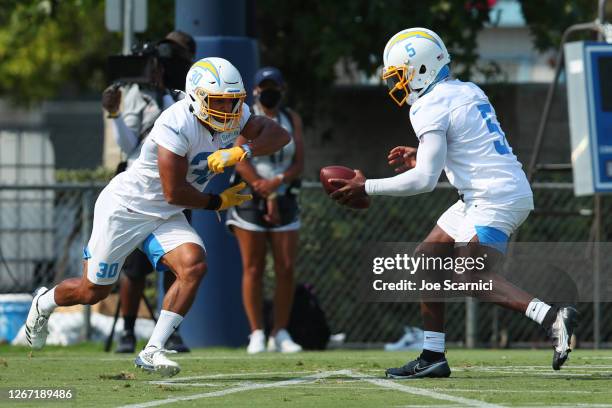 Tyrod Taylor of the Los Angeles Chargers hands the ball off to running back Austin Ekeler during Los Angeles Chargers Training Camp on August 19,...