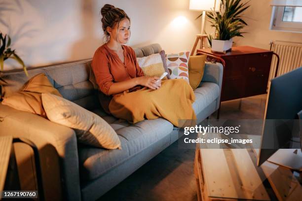 young women watching tv at home - changing channels stock pictures, royalty-free photos & images