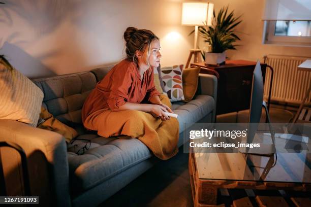 jeunes femmes regardant la télévision à la maison - chaîne de télévision photos et images de collection