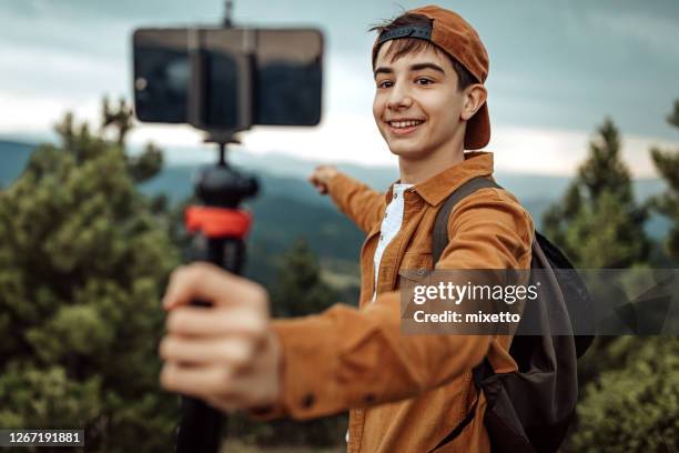 boy hiking and vlogging using mobile phone - youtuber stock pictures, royalty-free photos & images