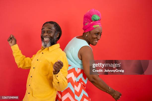 studio shot of playful black friends in 40s and 50s dancing - couple coloured background stock pictures, royalty-free photos & images