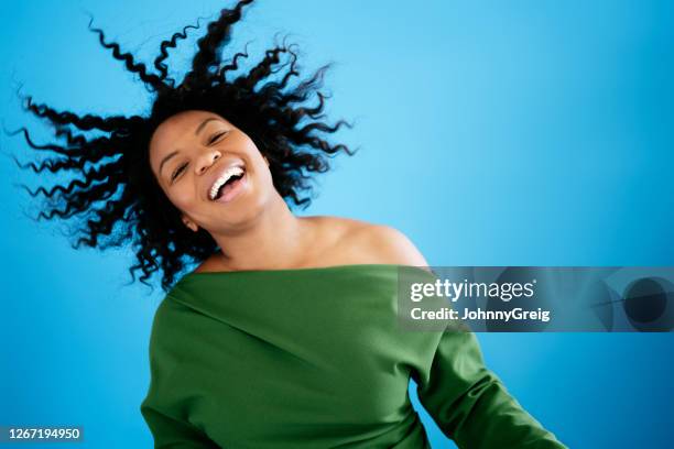 action portrait of late 20s black woman laughing and dancing - wind swept face stock pictures, royalty-free photos & images