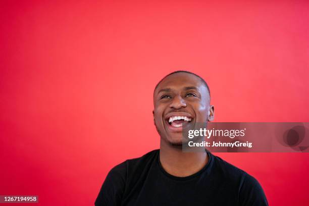 headshot of laughing young african man in black t-shirt - black t shirt stock pictures, royalty-free photos & images