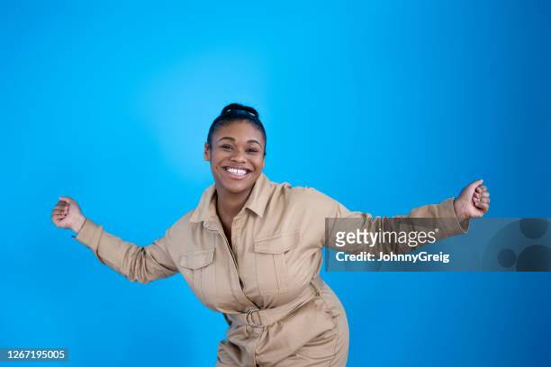 candid portrait of cheerful 19 year old black girl dancing - girls jumpsuit stock pictures, royalty-free photos & images